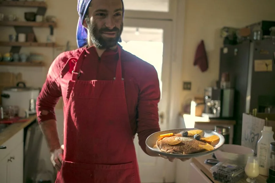 Josh in the kitchen holding a finished dish