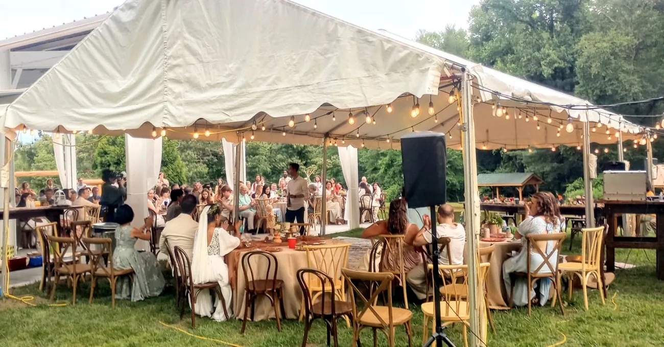 An outdoor tented wedding reception on private land